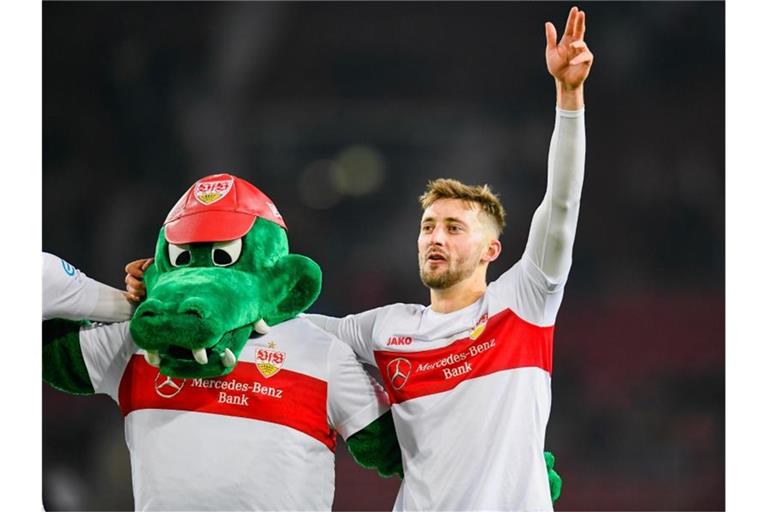 Nathaniel Phillips (r) vom VfB Stuttgart reagiert nach dem Spiel mit Maskotchen Frotzle (l). Foto: Tom Weller/dpa