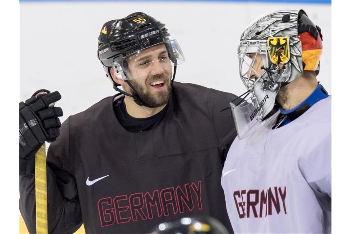 Nationalspieler Felix Schütz (l) spricht mit Goalie Dennis Endras (r). Foto: Peter Kneffel/dpa/Archivbild