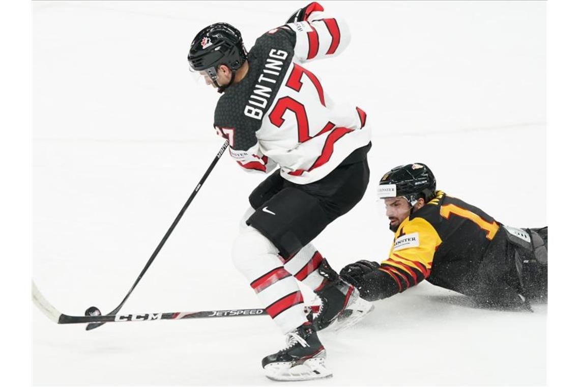 Nationalspieler Marco Nowak (r) stochert dem Kanadier Michael Bunting den Puck weg. Foto: Roman Koksarov/dpa