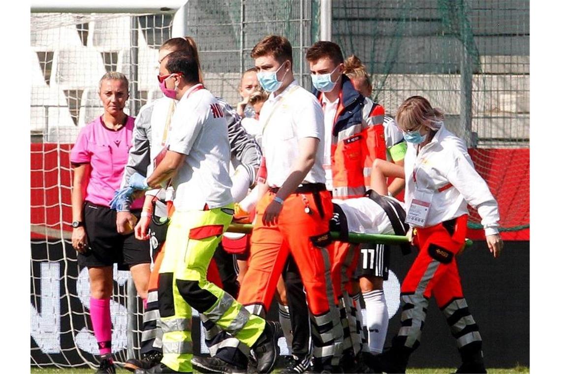 Nationalspielerin Giulia Gwinn wird verletzt vom Platz getragen und ins Krankenhaus gebracht. Foto: Roland Weihrauch/dpa