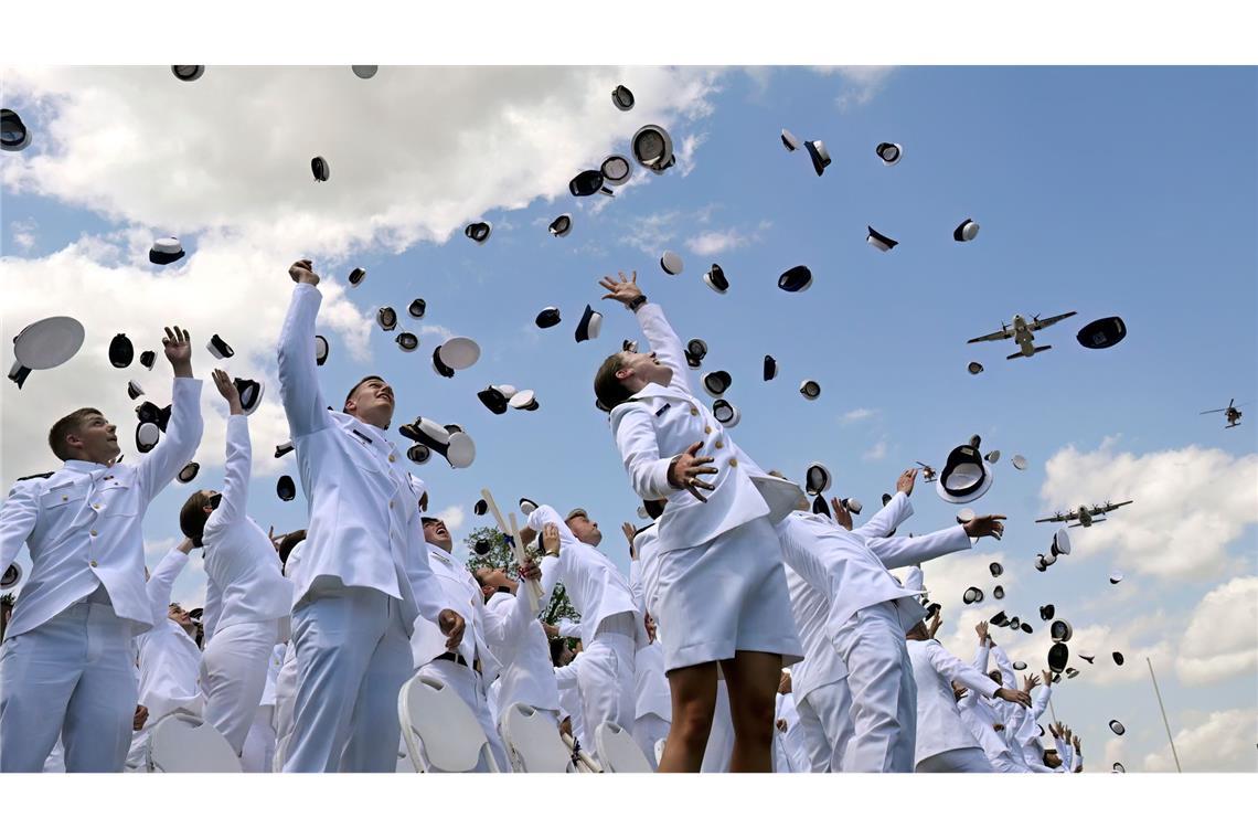Neu ernannte Fähnriche werfen ihre Mützen zum Abschluss der Feierlichkeiten an der United States Coast Guard Academy in New London in den USA.