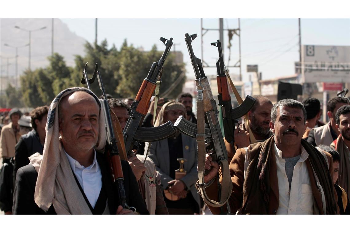 Neu rekrutierte Huthi-Kämpfer halten bei einer Zeremonie am Ende ihrer Ausbildung Waffen hoch und rufen Parolen.