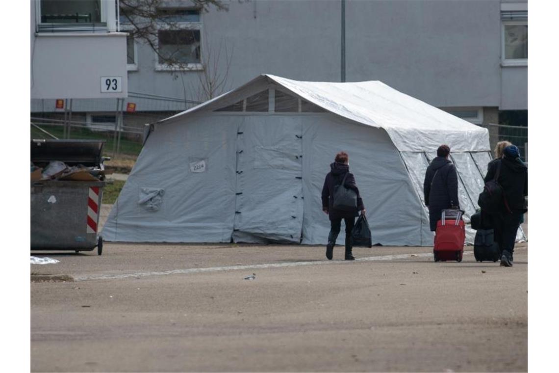 Neuankömmlinge gehen in der Landeserstaufnahmestelle (LEA) zu ihrem Quartier. Foto: Stefan Puchner/dpa/Archivbild