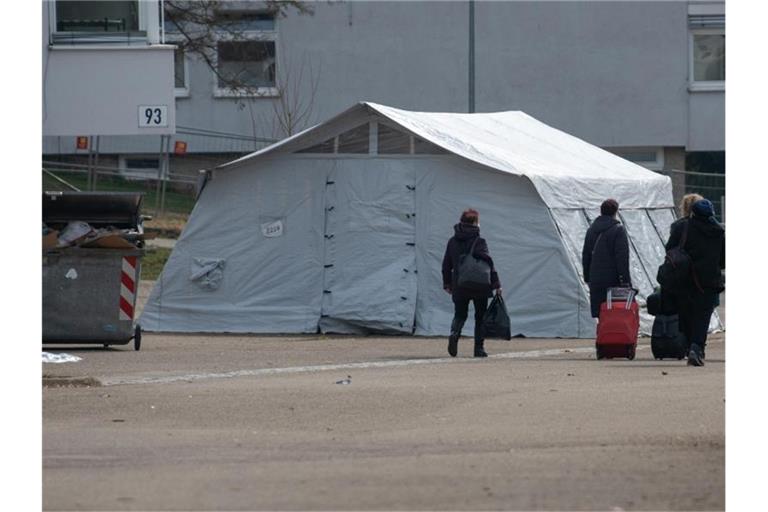 Neuankömmlinge gehen in der Landeserstaufnahmestelle (LEA) zu ihrem Quartier. Foto: Stefan Puchner/dpa/Archivbild