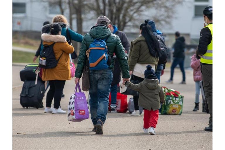 Neuankömmlinge gehen in einer Landeserstaufnahmestelle (LEA) zu ihrem Quartier. Foto: Stefan Puchner/dpa/Archivbild