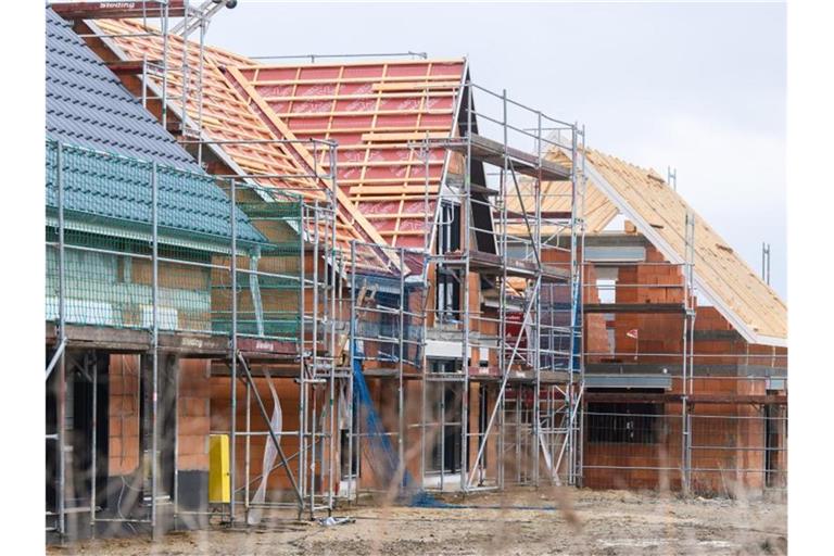 Neubauten stehen in einem Neubaugebiet in der Region Hannover. Die Preise für Baurohstoffe wie Holz, Beton und Stahl sind 2021 in die Höhe geschossen. Foto: Julian Stratenschulte/dpa