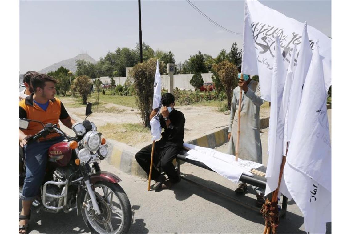 Weiterer Bundeswehr-Flieger evakuiert 205 Menschen aus Kabul Neue Machthaber, neue Fahne: In Kabul werden Flaggen der Taliban verkauft. Foto: -/kyodo/dpa
