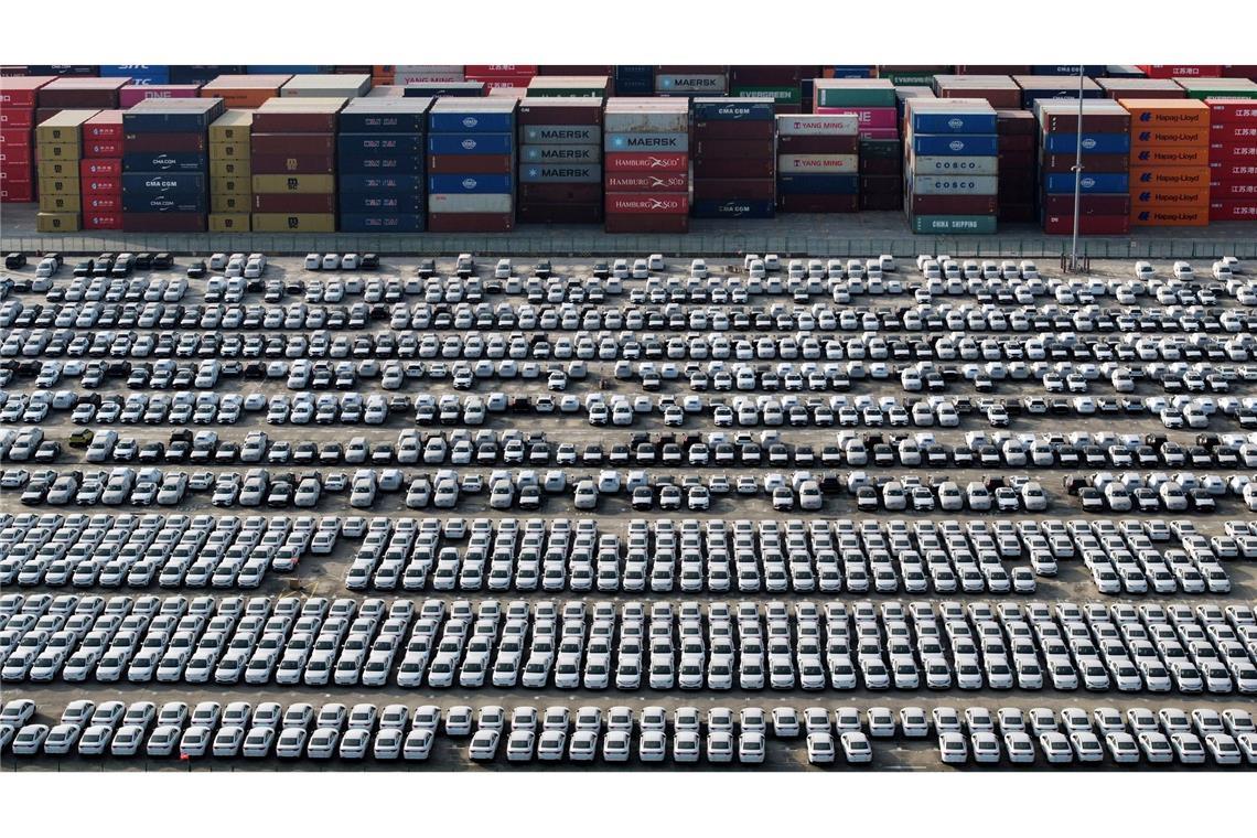 Bilder des Tages Neue Volvo-Fahrzeuge stehen neben Containern und warten auf ihre Verschiffung im Jangtse-Hafen in der Stadt Nanjing in der ostchinesischen Provinz Jiangsu.
