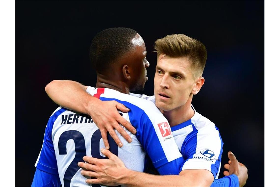 Neuzugang Krzysztof Piatek (r) und Dodi Lukebakio von Hertha umarmen sich nach Spielende. Foto: Soeren Stache/dpa-Zentralbild/dpa