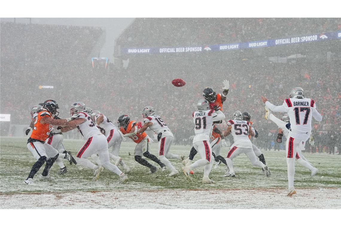 New England Patriots Punter Bryce Baringer (M) bei Schneefall in Aktion.