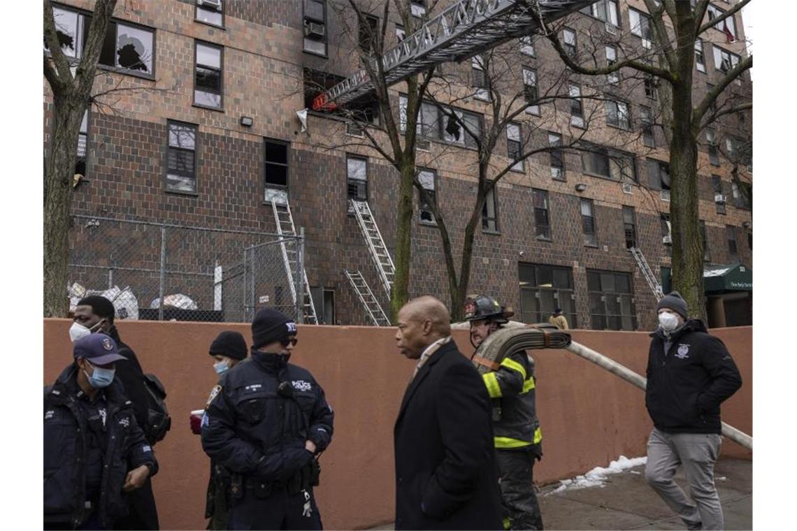 Trauer in New York nach schwerem Wohnhausbrand New Yorks Bürgermeister Eric Adams (3.v.r) kam zum Brandort. Foto: Yuki Iwamura/AP/dpa