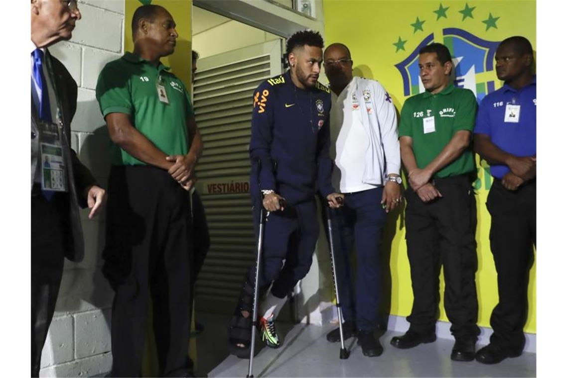 Neymar (M) verlässt die Umkleidekabine der Brasilianer an Krücken, nachdem er sich während des Spiels gegen Katar verletzt hat. Foto: Andre Penner/AP