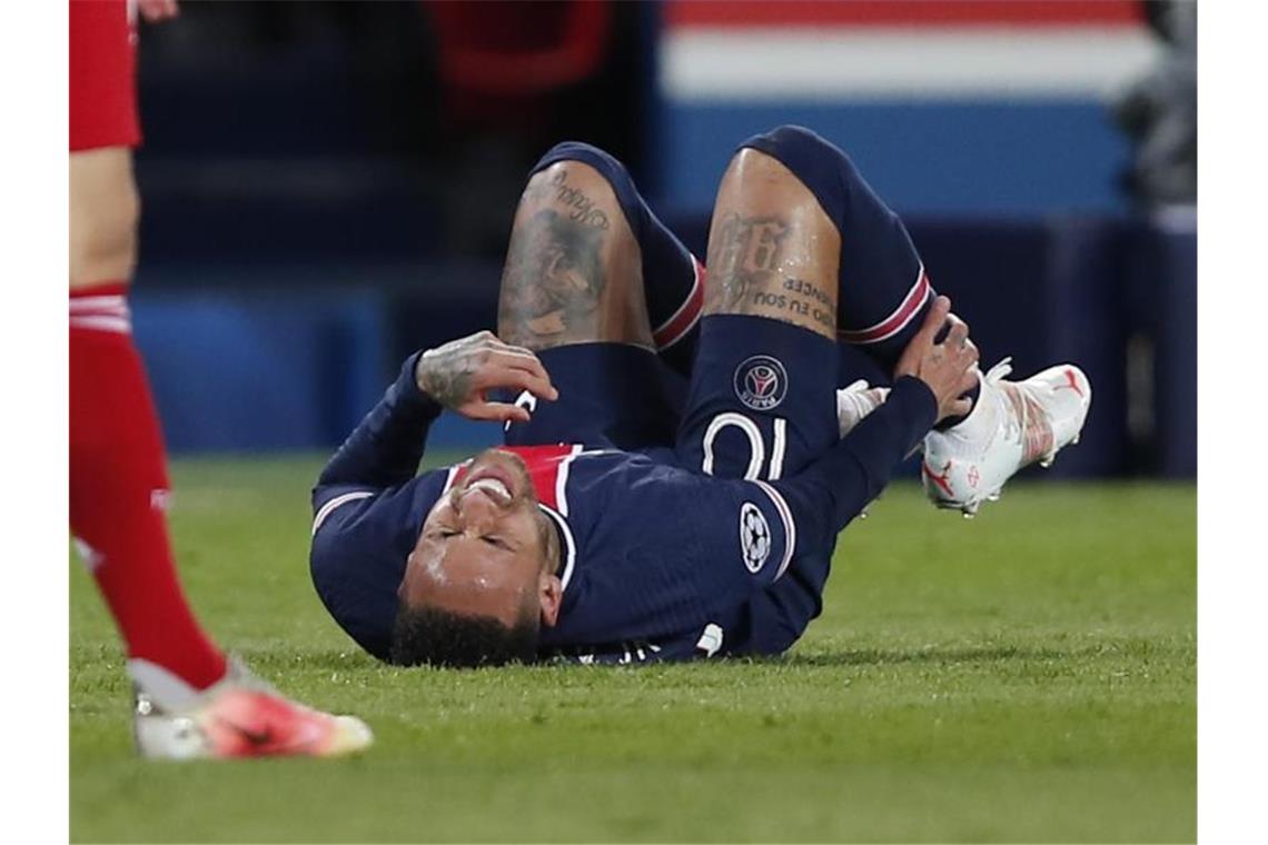 Neymar von Paris Saint-Germain liegt mit schmerzverzerrtem Gesicht auf dem Spielfeld und hält sich den Unterschenkel. Foto: Francois Mori/AP/dpa