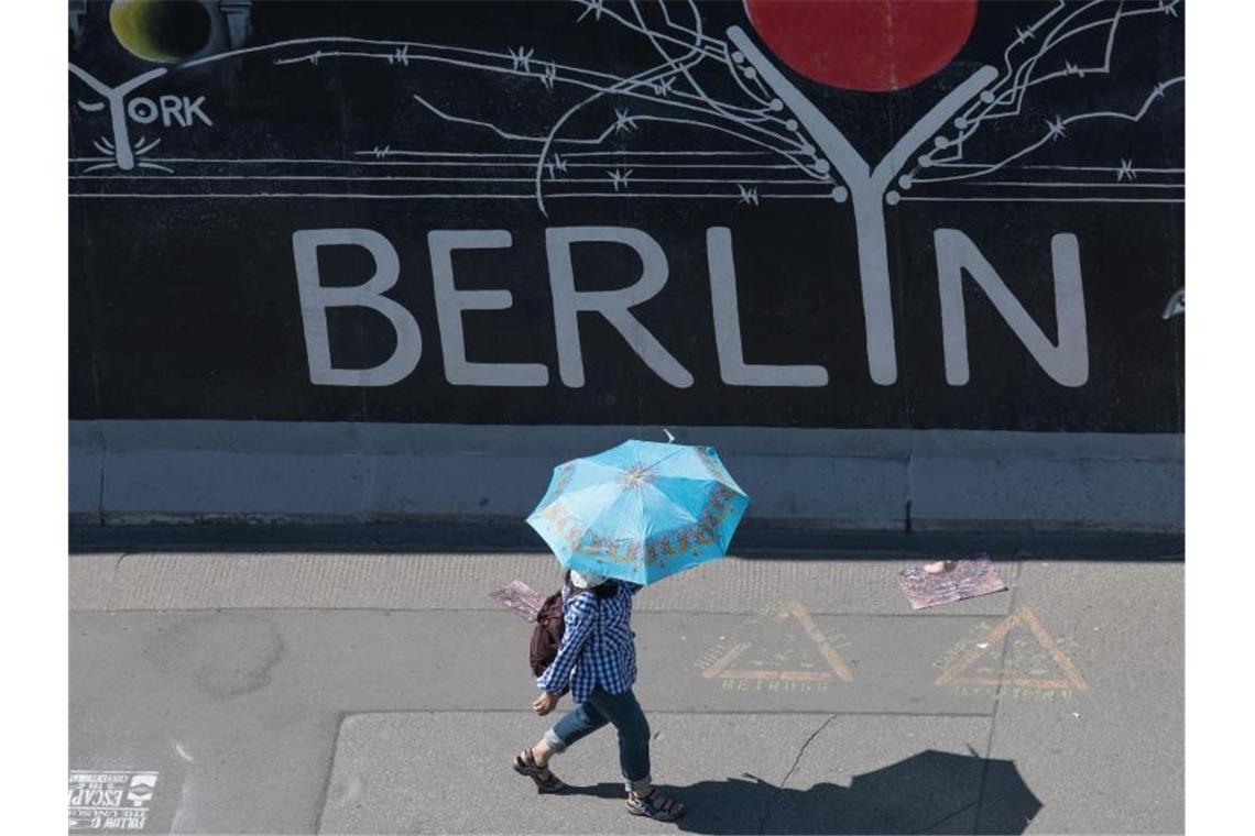 Nicht nur bei Nieselwetter hilfreich: Eine Touristin nutzt einen Regenschirm als Schutz gegen die Sonne. Foto: Jörg Carstensen