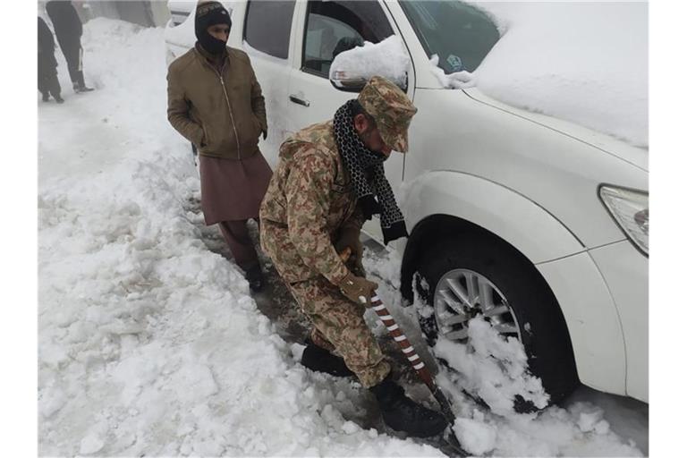 Nichts geht mehr, ein Soldat hilft: Nach einem heftigen Wintereinbruch im Norden Pakistans sind mindestens 21 Urlauber ums Leben gekommen. Foto: -/Inter Services Public Relations/AP/dpa