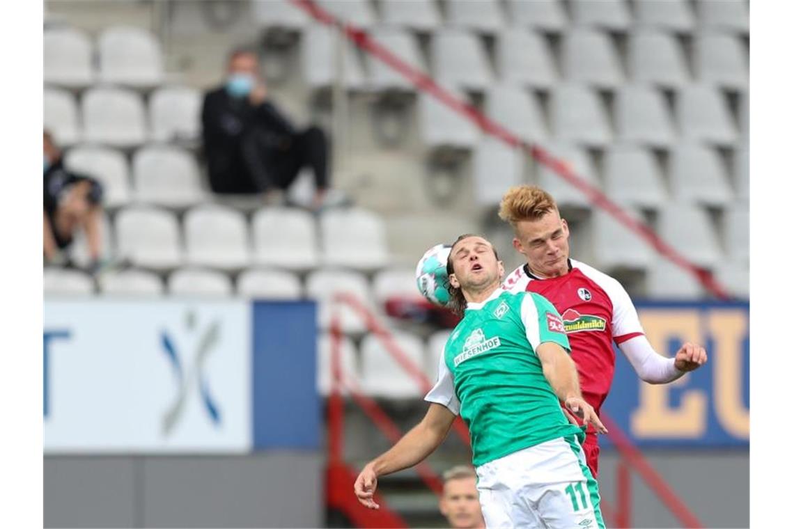 Niclas Füllkrug (l) sicherte Werder Bremen einen Punkt in Freiburg. Foto: Tom Weller/dpa