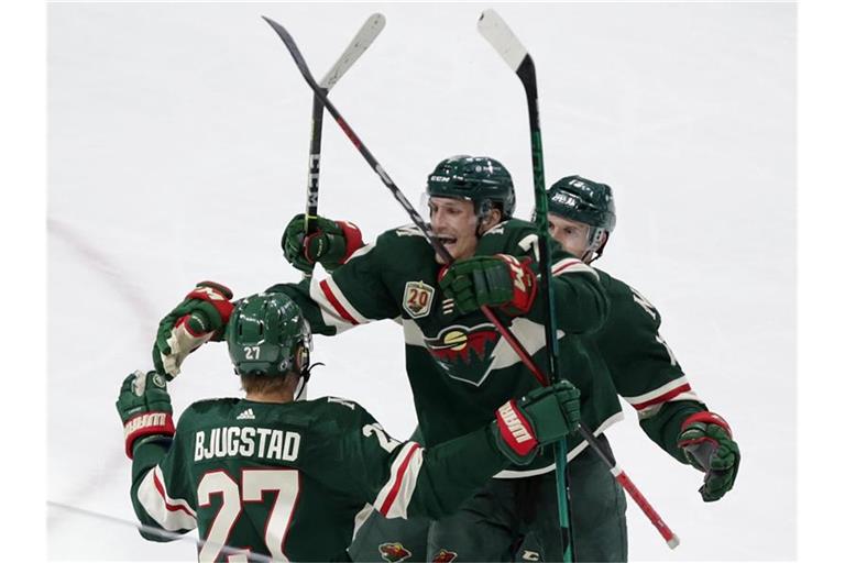 Nico Sturm (M.) jubelt mit seinen Wild-Teamkollegen Nick Bjugstad (l) und Nick Bonino. Foto: Andy Clayton-King/AP/dpa