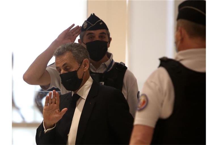 Nicolas Sarkozy (M) kommt am 15. Juni 2021 in einem Pariser Gerichtsgebäude an. Im Prozess gegen den früheren französischen Präsidenten wegen mutmaßlich überhöhter Wahlkampfkosten wird heute ein Urteil erwartet. Foto: Rafael Yaghobzadeh/AP/dpa