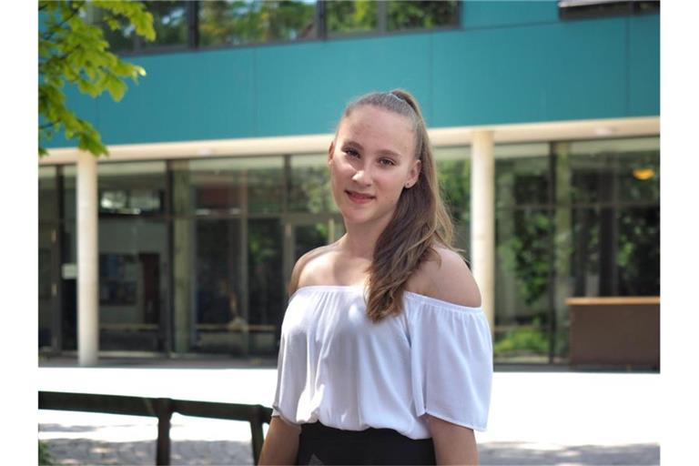 Niedersachsens jüngste Abiturientin Mandy Hoffmann steht mit Blumen in der Hand vor ihrer Schule. Mandy hat mit 14 Jahren das Abitur mit der Note 1,0 bestanden. Foto: Katrin Hoffmann