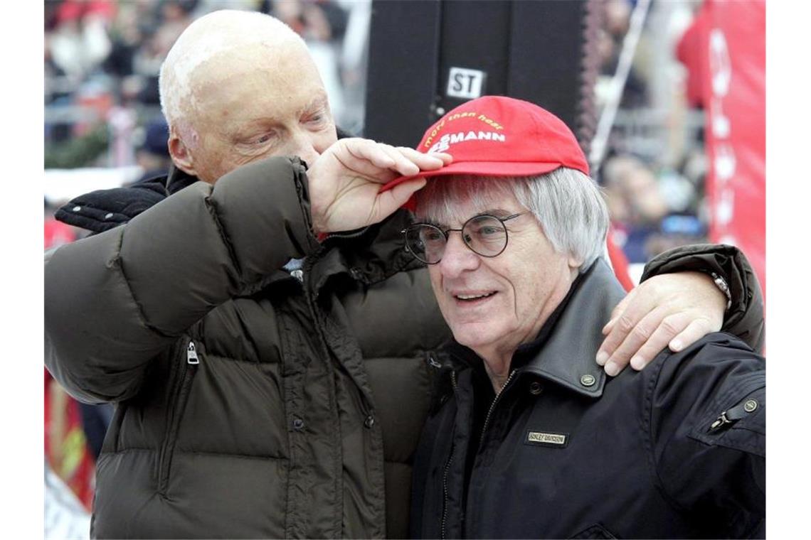 Niki Lauda (l) setzt 2006 dem damalige Formel-1-Chef Bernie Ecclestone seine rote Kappe auf. Foto: Harald Schneider/APA
