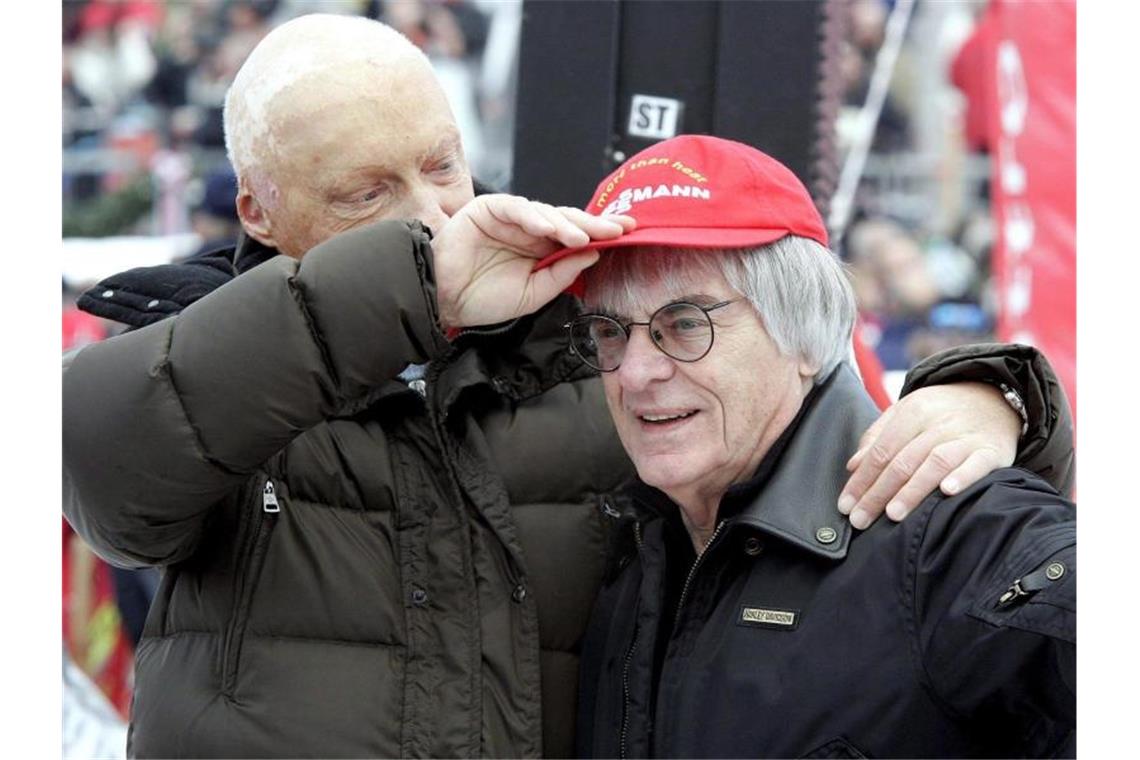 Der Mann mit der roten Kappe: Niki Lauda bleibt unvergessen Niki Lauda (l) setzt 2006 dem damalige Formel-1-Chef Bernie Ecclestone seine rote Kappe auf. Foto: Harald Schneider/APA
