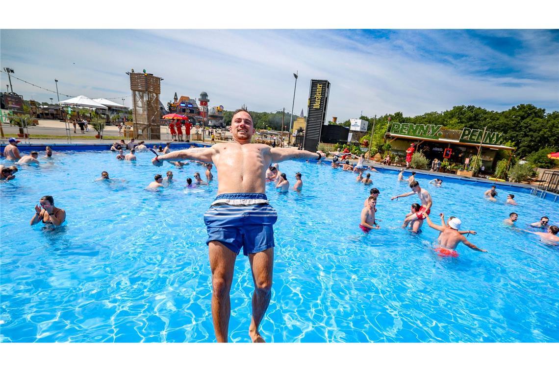 Bilder des Tages Niklas H.aus Heideburg in Rheinland-Pfalz springt bei sommerlichen Temperaturen rückwärts in den großen Pool auf dem Festivalgelände.