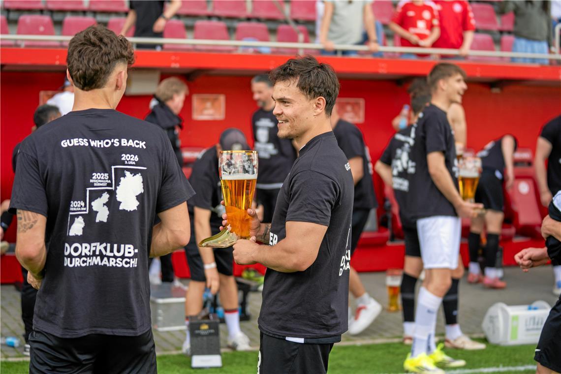 Niklas Pollex hat einen Stiefel mit Bier in den Händen. 