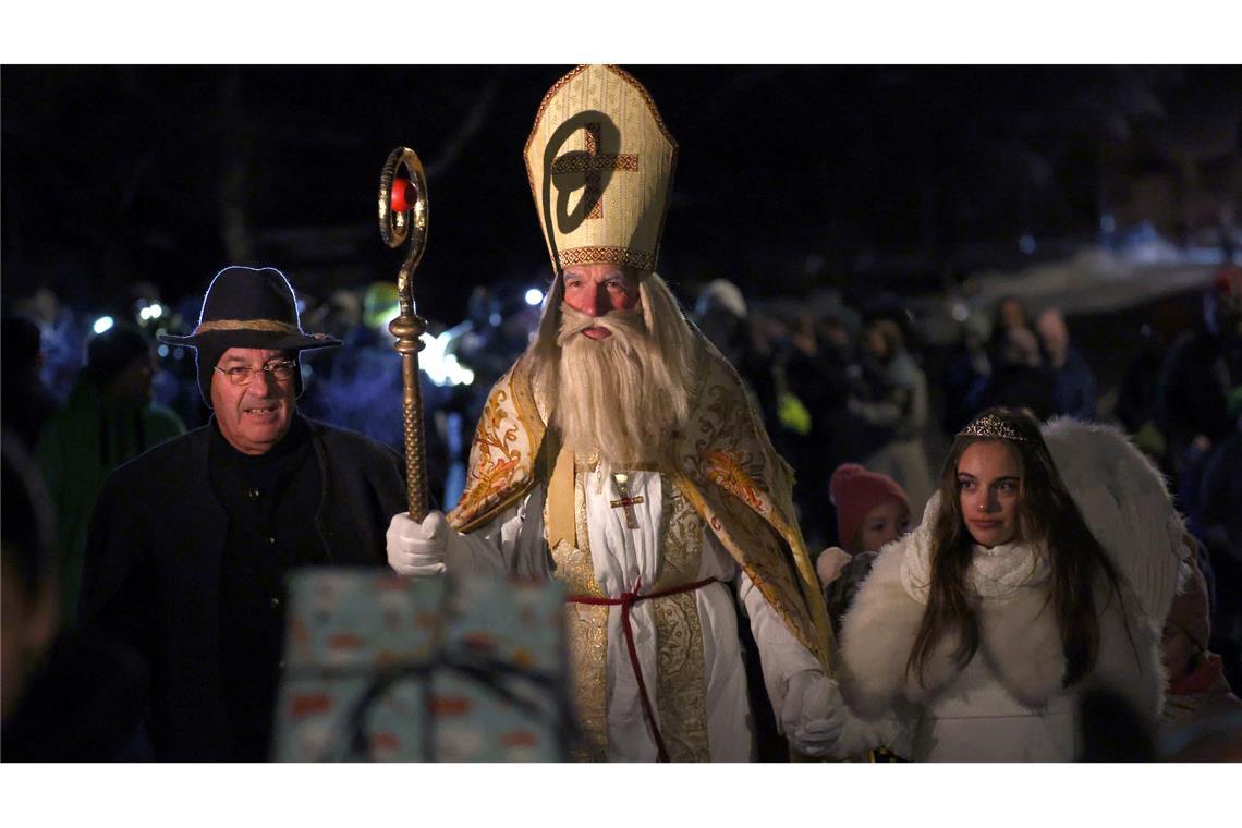 Nikolausdarsteller ziehen beim 13. Internationalen Nikolaus-Treffen in einem Umzug in Richtung der Pfarrkirche Sankt Martin in Missen-Wilhams.