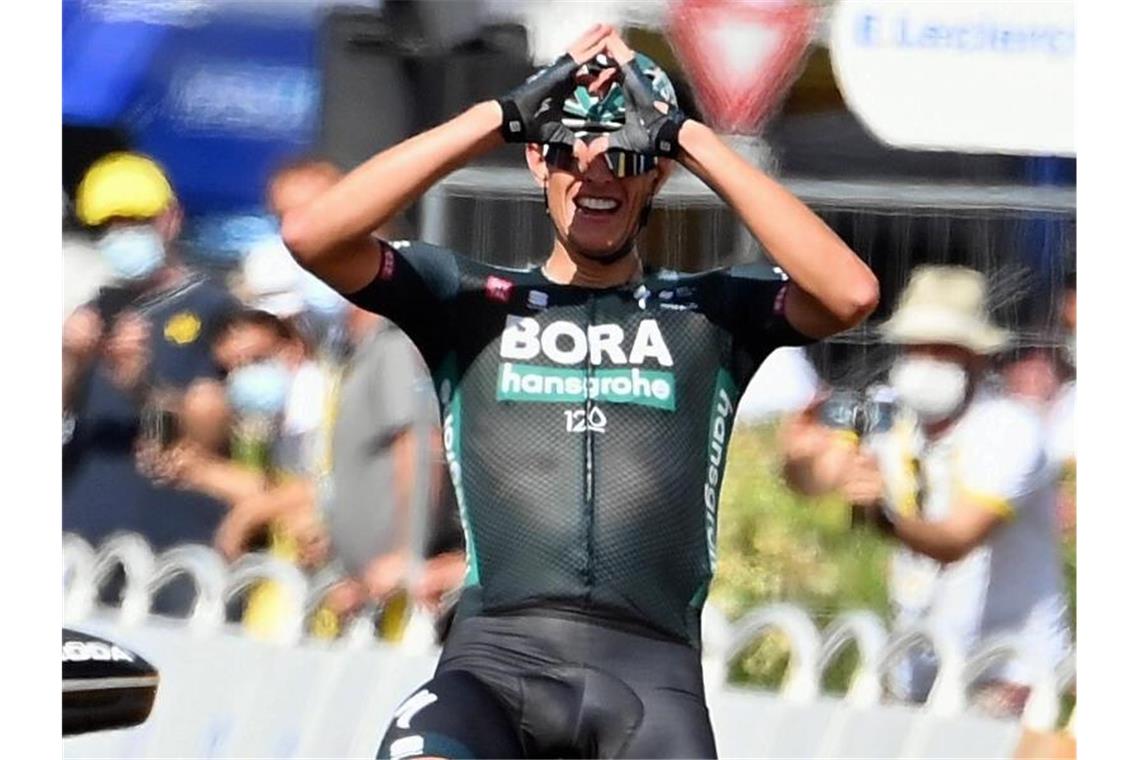 Nils Politt formt nach seinem Tagessieg bei der Tour de France mit den Händen im Ziel ein Herz. Foto: David Stockman/BELGA/dpa