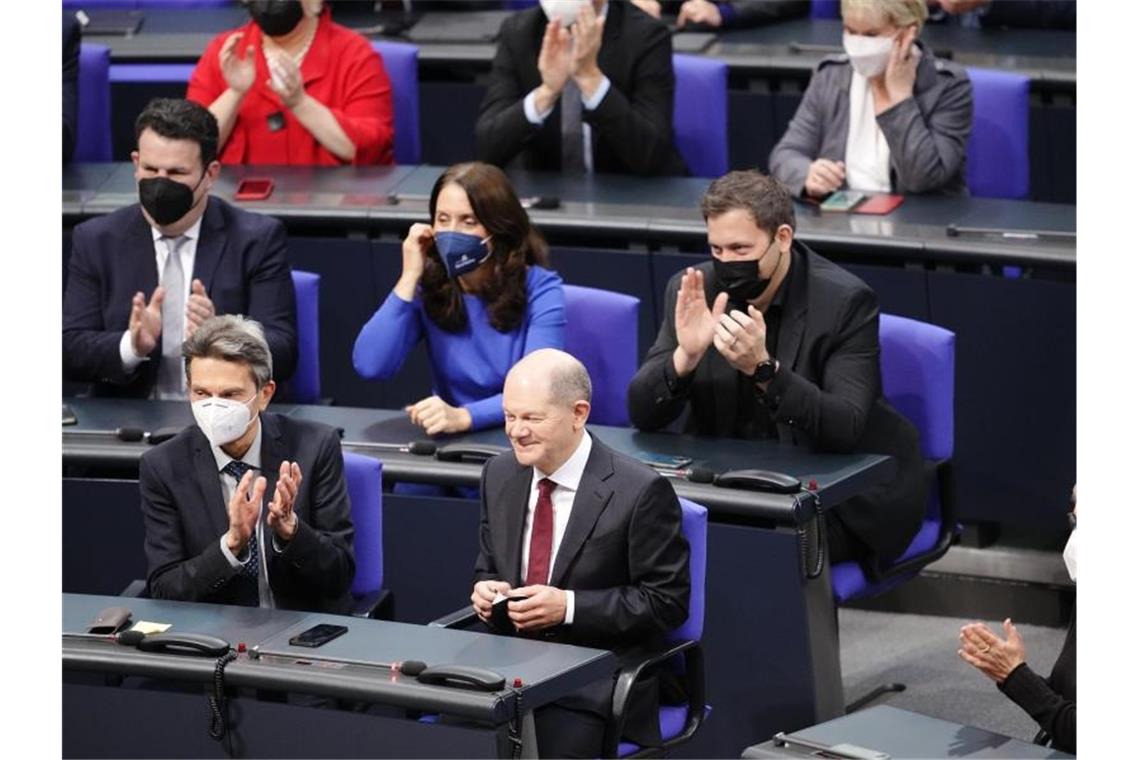 Neue Ampel-Regierung: Scholz sagt Corona dem Kampf an Nimmt mit einem Grinsen im Gesicht die Wahl zum Bundeskanzler an: Olaf Scholz. Foto: Kay Nietfeld/dpa