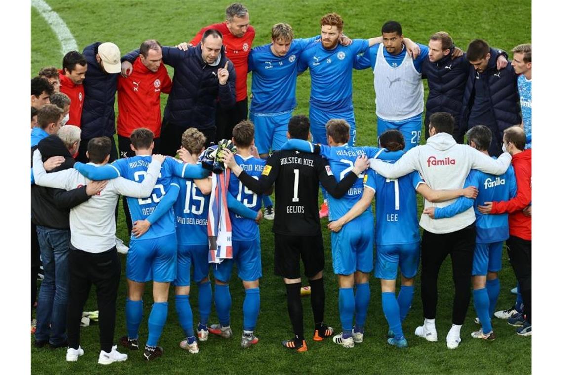 Noch auf dem Kölner Rasen schwört Holstein-Coach Ole Werner seine Spieler auf das Rückspiel in Kiel ein. Foto: Rolf Vennenbernd/dpa Pool/dpa