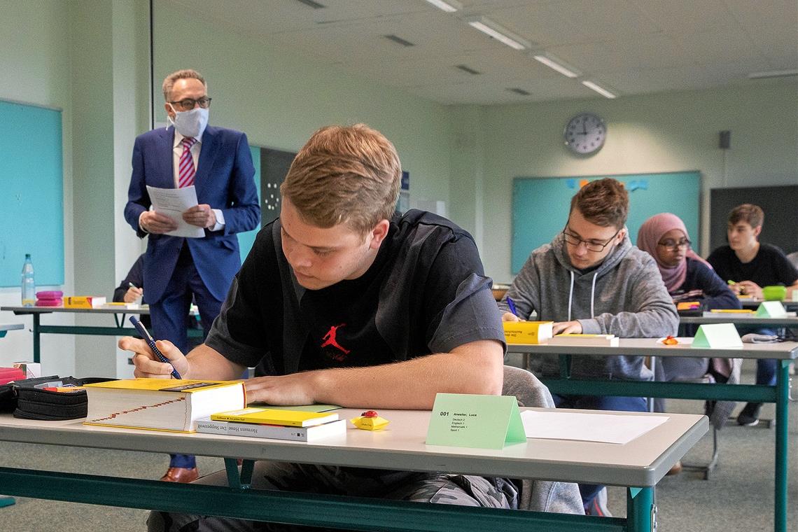 Deutsch-Abi unter besonderen Vorzeichen Noch eine Minute, dann darf Luca Arweiler (im Vordergrund) die Aufgaben ansehen. Schulleiter Udo Weisshaar vom Tausgymnasium achtet darauf, dass die Formalitäten befolgt werden. Foto: J. Fiedler