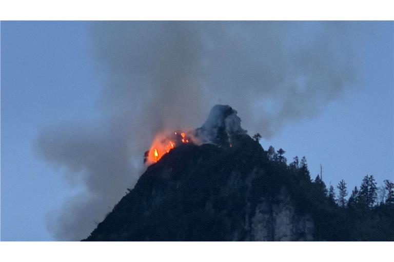 Noch immer steigen große Rauchwolken aus einem bewaldeten Berg bei Ruhpolding (Landkreis Traunstein) auf.