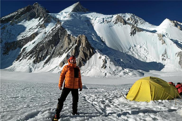 Noch ist alles in Ordnung: Marc Grün steht vor seinem Zelt im ersten Hochlager, hinter ihm der Gipfel des Gasherbrum II. Später wird er mit seiner Gruppe hier eingeschneit und tritt den gefährlichen Rückweg an. Gute Fotos sind fortan die kleinste Sorge. Foto: privat