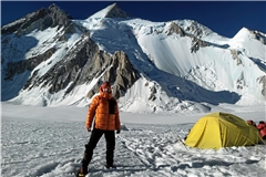 Noch ist alles in Ordnung: Marc Grün steht vor seinem Zelt im ersten Hochlager, hinter ihm der Gipfel des Gasherbrum II. Später wird er mit seiner Gruppe hier eingeschneit und tritt den gefährlichen Rückweg an. Gute Fotos sind fortan die kleinste Sorge. Foto: privat