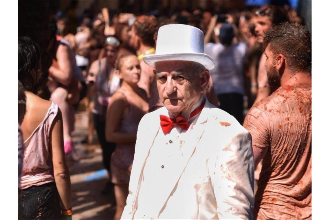 Tomatenkrieg in Spanien: 22.000 Menschen bei „La Tomatina“ Noch ist er weiß: Ein Mann in Anzug und Hut bei der traditionsreichen Tomatenschlacht „La Tomatina“ in Buñol. Foto: Jorge Gil/Europa Press
