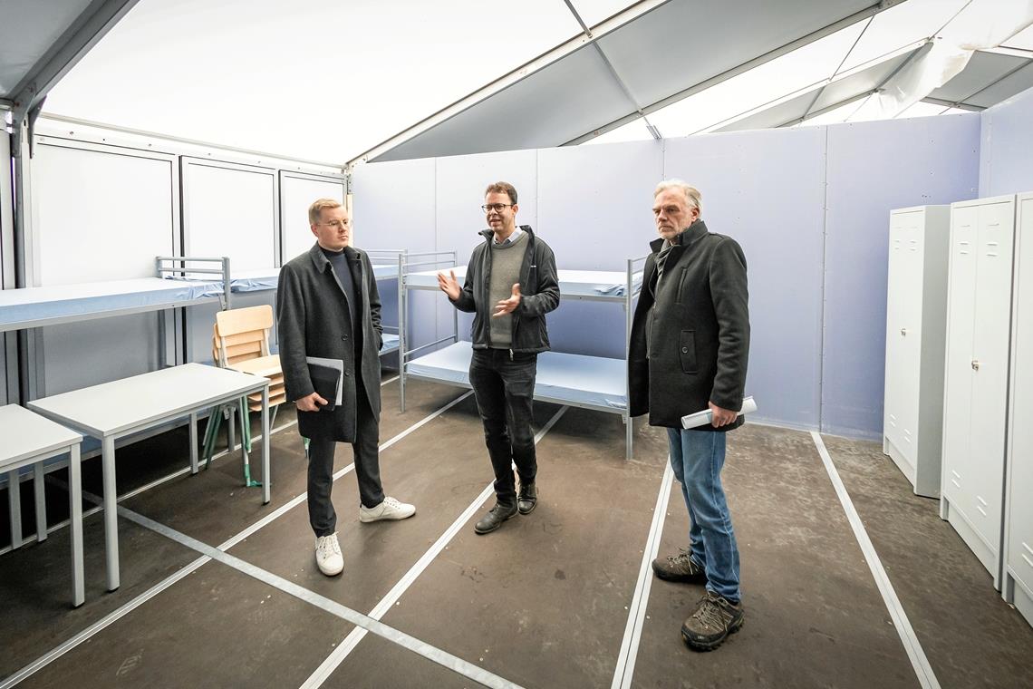 Zeltunterkunft in Backnang bleibt vorerst nur Reserve Noch sind die Betten leer: Fachbereichsleiter Steffen Blunck und Dezernent Peter Zaar vom Landratsamt sowie Jens Kitter von der Kreisbaugruppe (von links) beim Ortstermin in der Zeltunterkunft beim Backnanger Berufsschulzentrum. Foto: Alexander Becher
