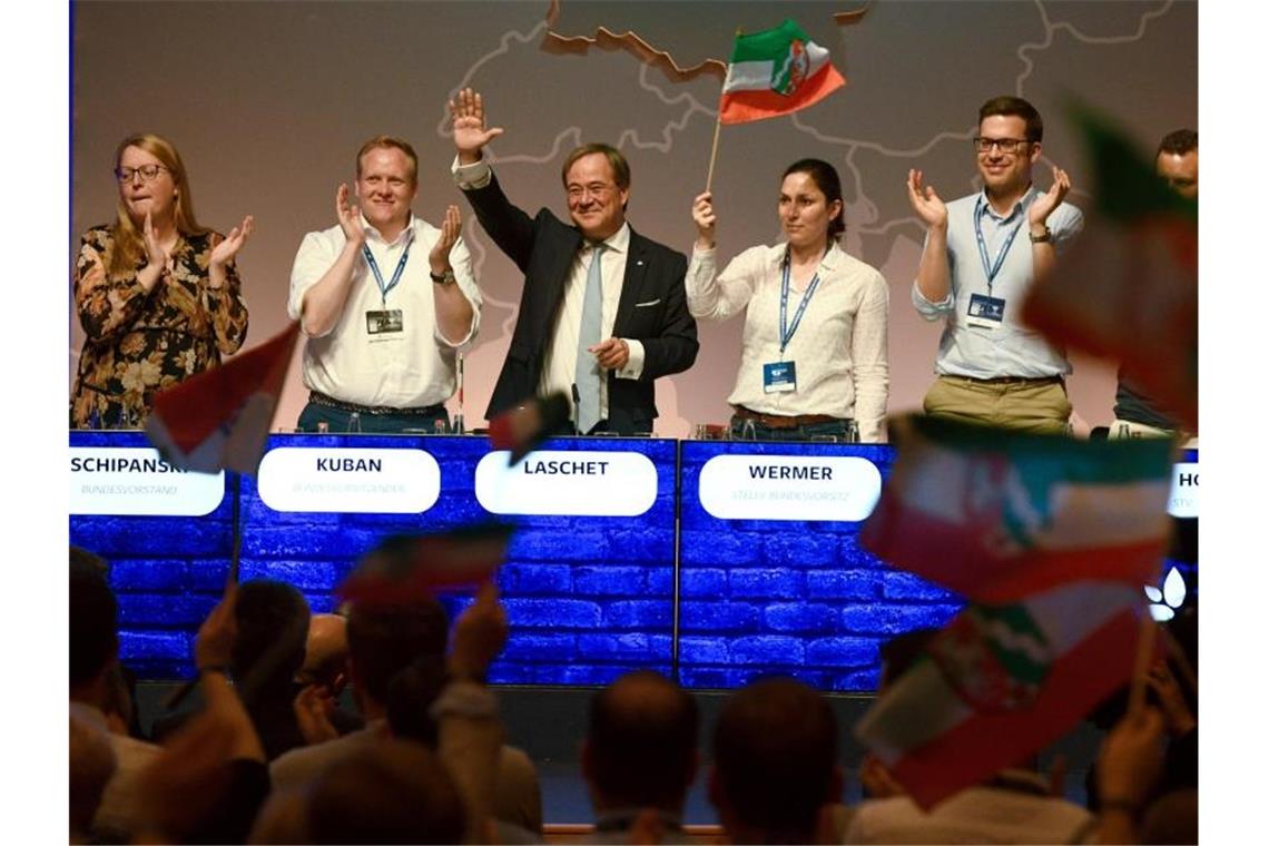 Union ringt auf JU-Deutschlandtag um Geschlossenheit Nordrhein-Westfalens Regierungschef Armin Laschet winkt beim Deutschlandtag der Jungen Union vom Podium. Neben ihm steht der JU-Bundesvorsitzende Tilman Kuban. Foto: Harald Tittel/dpa