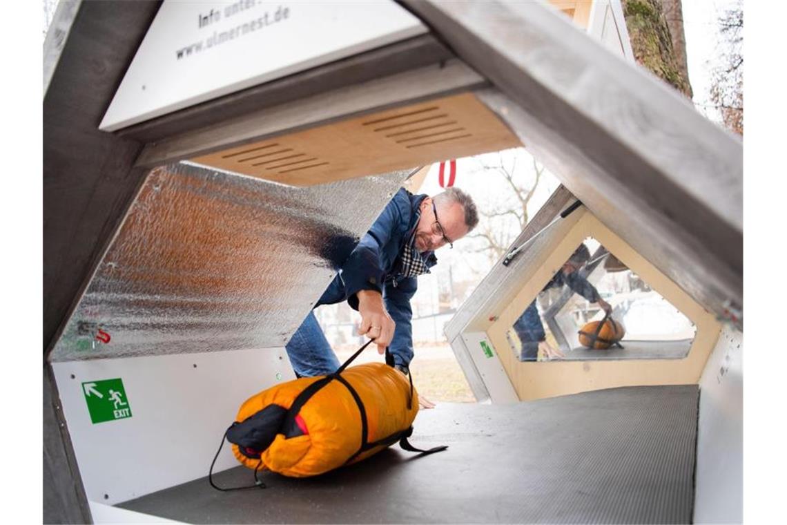 Norman Kurock, Mitarbeiter der Caritas Ulm-Alb-Donau, holt am morgen einen Schlafsack aus dem Ulmer Nest. Foto: Tom Weller/dpa/Archiv