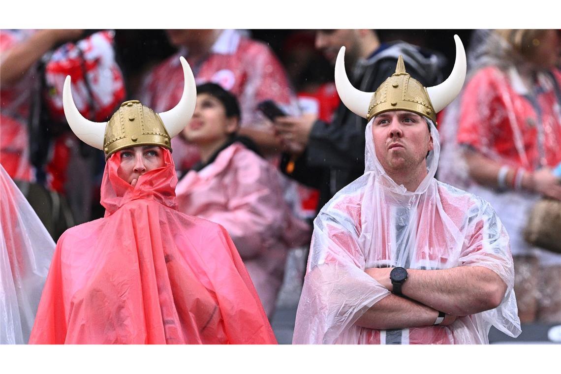 Norwegische Fans mit Regenschutz stehen vor dem Spiel im Stadion.