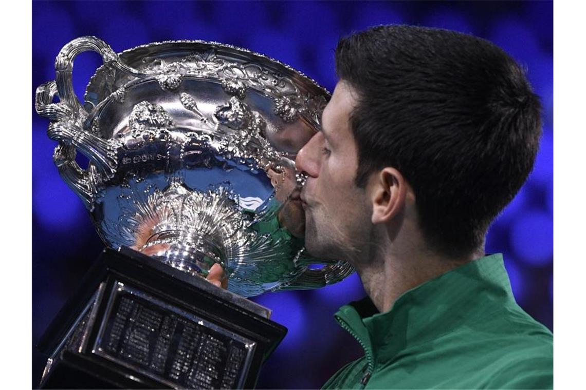 Djokovic zum achten Mal Australian-Open-Champion Novak Djokovic küsst nach dem hart erkämpften Finalsieg gegen Thiem den Siegerpokal. Foto: Andy Brownbill/AP/dpa