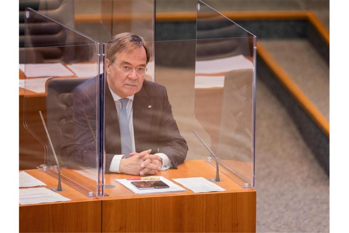 NRW-Ministerpräsident Armin Laschet sitzt im Plenum des Düsseldorfer Landtags in einer Plexiglas-Box. Foto: Rolf Vennenbernd/dpa