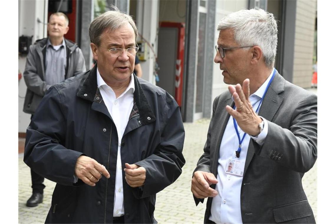 NRW-Ministerpräsident Armin Laschet zusammen mit dem Hagener Oberbürgermeister Erik O. Schulz, nachdem er sich ein Bild von der Lage in der Stadt gemacht hat. Foto: Roberto Pfeil/dpa