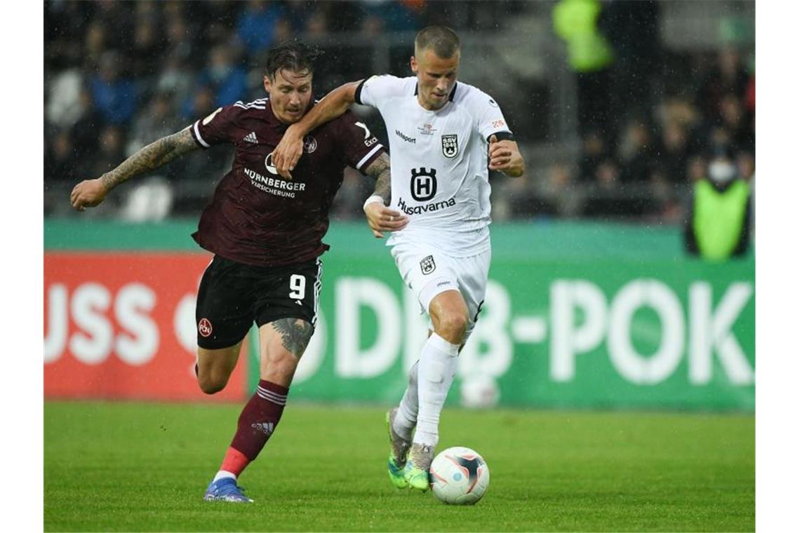 Dumans Traumtor erlöst Nürnberger: „Den wollte ich so“ Nürnbergs Manuel Schäffler (l) und Ulms Adrian Beck kämpfen um den Ball. Foto: Silas Stein/dpa