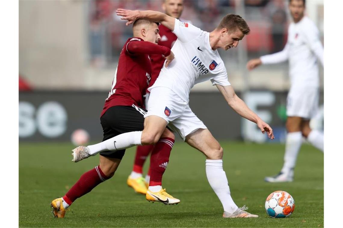 1. FC Nürnberg „total euphorisch“: Tempelmanns „super Spiel“ Nürnbergs Nikola Dovedan (l) kämpft mit Heidenheims Jan Schöppner um den Ball. Foto: Daniel Karmann/dpa