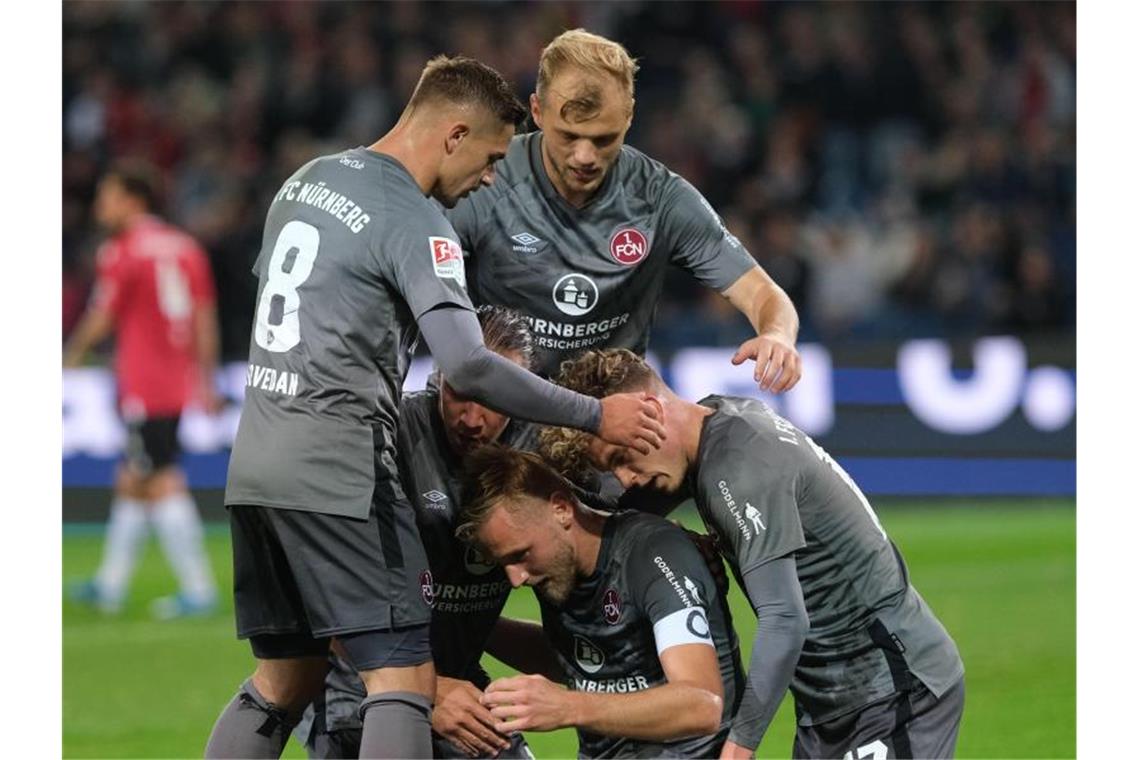 Nürnbergs Spieler feiern Torschütze Hanno Behrens (unten, M) nach seinem Treffer zum 2:0 gegen Hannover 96. Foto: Peter Steffen
