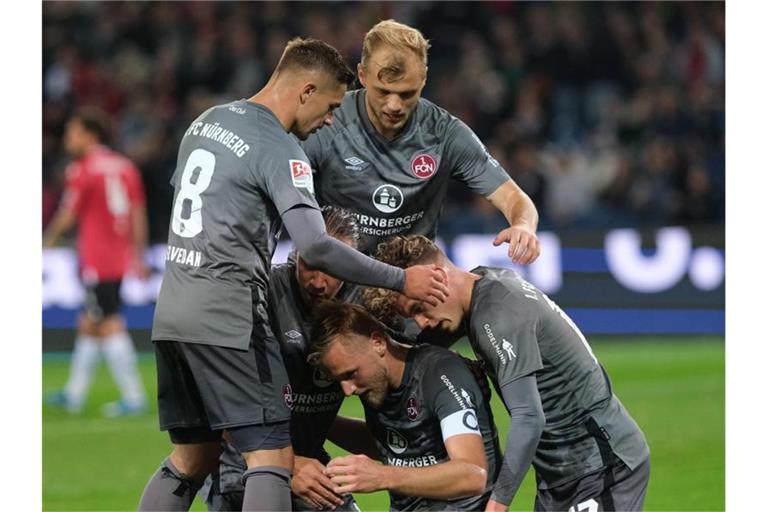 Nürnbergs Spieler feiern Torschütze Hanno Behrens (unten, M) nach seinem Treffer zum 2:0 gegen Hannover 96. Foto: Peter Steffen