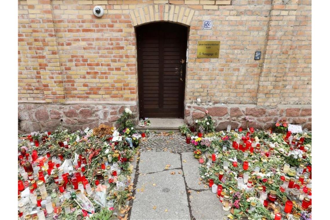 Nur noch ein schmaler Weg führt zwischen den Blumen und Kerzen zur Tür der Synagoge Halle. Foto: Jan Woitas/dpa-Zentralbild/dpa