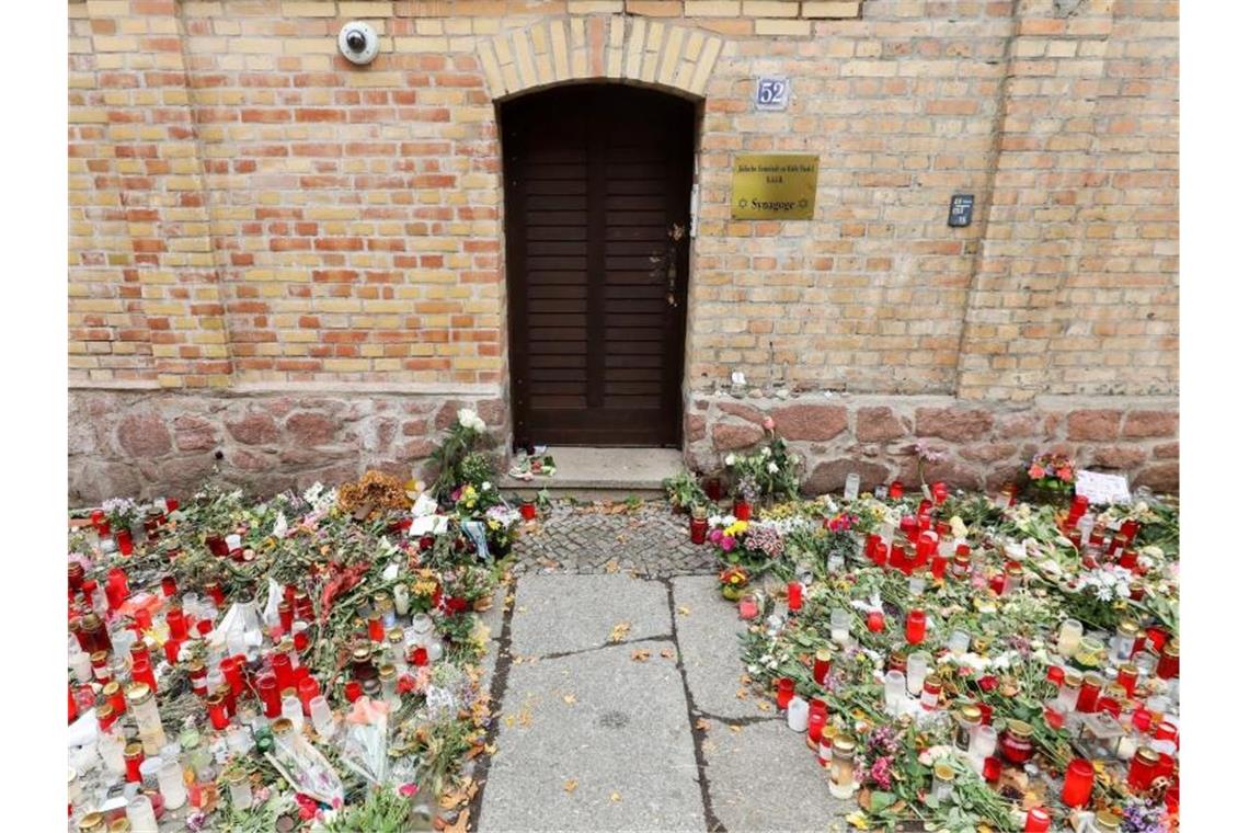Nur noch ein schmaler Weg führt zwischen den Blumen und Kerzen zur Tür der Synagoge Halle. Foto: Jan Woitas/dpa-Zentralbild/dpa