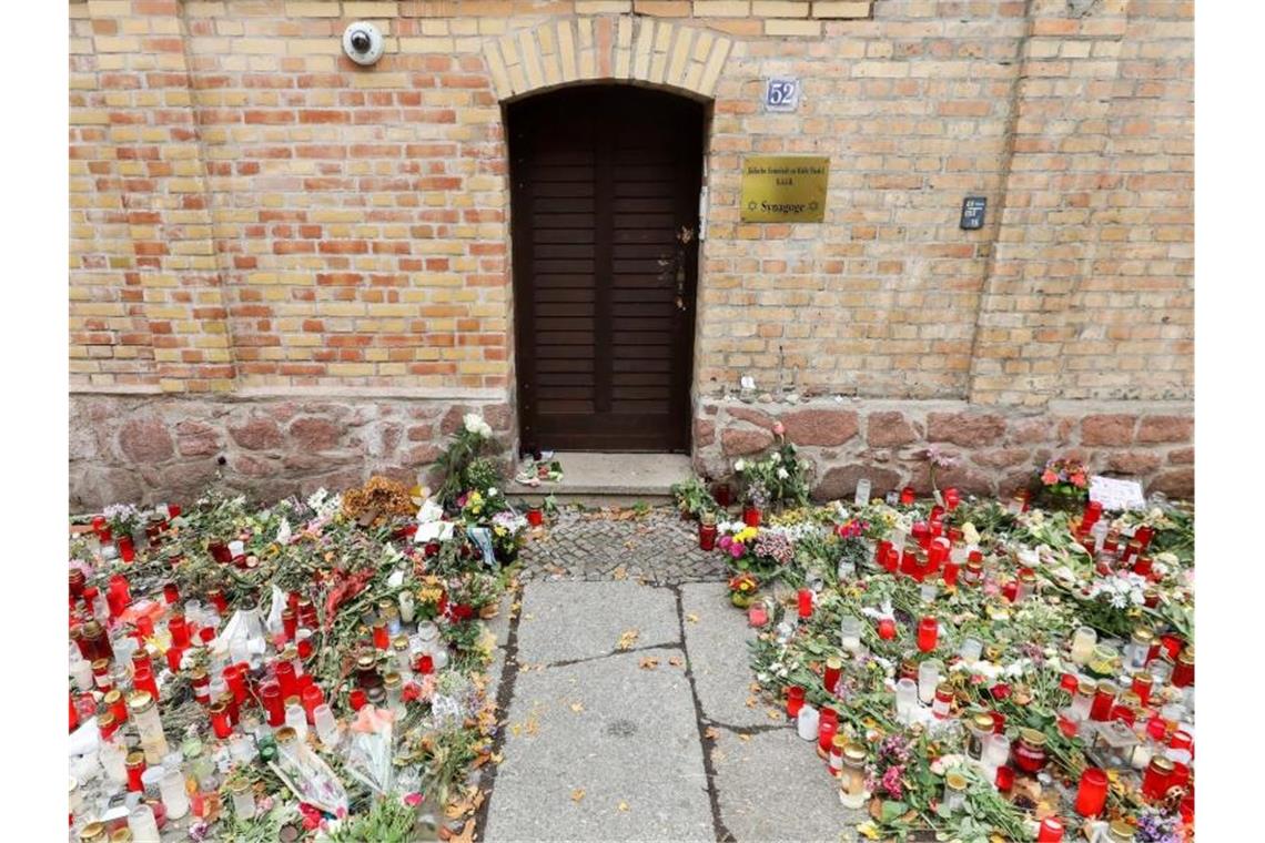 Den Hass leise machen: Konzert für Anschlagsopfer von Halle Nur noch ein schmaler Weg führt zwischen den Blumen und Kerzen zur Tür der Synagoge Halle. Foto: Jan Woitas/dpa-Zentralbild/dpa